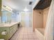 Bathroom with a long pale green vanity, tile floor, and shower/tub combo at 38327 Palm Grove Dr, Zephyrhills, FL 33542