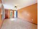 Bedroom features tile floors, ceiling fan, closet, and view to bathroom at 38327 Palm Grove Dr, Zephyrhills, FL 33542
