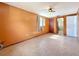 Bedroom with orange walls, neutral tile, ceiling fan, and natural light from a double window at 38327 Palm Grove Dr, Zephyrhills, FL 33542