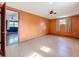 Large bedroom features tile floors, ceiling fan, window, and view to second bedroom at 38327 Palm Grove Dr, Zephyrhills, FL 33542
