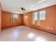 Large bedroom features tile floor, ceiling fan, and two bright windows at 38327 Palm Grove Dr, Zephyrhills, FL 33542
