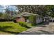A single-story brick home with an adjacent detached garage at 38327 Palm Grove Dr, Zephyrhills, FL 33542