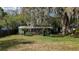 Home exterior featuring screen enclosed porch, framed by palms, offering a unique charm and appeal at 38327 Palm Grove Dr, Zephyrhills, FL 33542