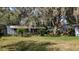 Home exterior featuring screen enclosed porch and palms, blending with nature for peaceful living at 38327 Palm Grove Dr, Zephyrhills, FL 33542
