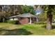 A charming single-story home with brick facade and manicured bushes at 38327 Palm Grove Dr, Zephyrhills, FL 33542