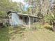 Home exterior with screen enclosed porch with landscaping, offering a relaxing outdoor living space at 38327 Palm Grove Dr, Zephyrhills, FL 33542