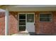 A close-up of the brick house's front entrance, showing its number and front door at 38327 Palm Grove Dr, Zephyrhills, FL 33542