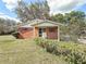 Charming single-story brick home with a covered front porch and well-maintained landscaping at 38327 Palm Grove Dr, Zephyrhills, FL 33542