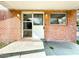 Close-up of the brick facade and covered front porch with white door and windows at 38327 Palm Grove Dr, Zephyrhills, FL 33542