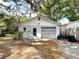Garage with gray door, small window, and side door at 38327 Palm Grove Dr, Zephyrhills, FL 33542