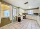 Spacious kitchen shows window, tile floor, painted cabinets, and appliances at 38327 Palm Grove Dr, Zephyrhills, FL 33542