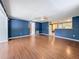 Open living space with wood-look flooring, blue walls, and seamless transition to the kitchen at 38327 Palm Grove Dr, Zephyrhills, FL 33542