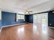 Large living room featuring wood-look floors, blue walls, and multiple windows at 38327 Palm Grove Dr, Zephyrhills, FL 33542