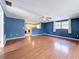 Spacious living room with wood-look flooring, blue walls, and plenty of natural light at 38327 Palm Grove Dr, Zephyrhills, FL 33542