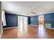 Bright and airy living room with wood-look flooring, blue walls, and easy access to other rooms at 38327 Palm Grove Dr, Zephyrhills, FL 33542