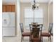 Bright dining area with a white refrigerator, a glass table, chairs, and a chandelier at 416 Durham Shore Ct, Apollo Beach, FL 33572