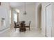 Bright dining area boasts high ceilings, decorative chandelier, and a glass top table with seating for four at 416 Durham Shore Ct, Apollo Beach, FL 33572