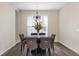A dining area with a large window, modern chandelier, and upholstered chairs with nailhead trim at 416 Durham Shore Ct, Apollo Beach, FL 33572