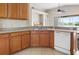 Well-lit kitchen with wood cabinets, modern appliances, and a breakfast bar overlooking a serene backyard at 416 Durham Shore Ct, Apollo Beach, FL 33572
