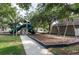 Community playground featuring play structure with slides and swings, set among mature trees for shade at 416 Durham Shore Ct, Apollo Beach, FL 33572