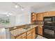Open kitchen featuring oak cabinetry, granite countertops, stainless steel sink, and tiled floors at 4207 S Dale Mabry Hwy # 12206, Tampa, FL 33611