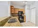Kitchen with oak cabinetry, granite countertops, tiled floors and stainless steel sink at 4207 S Dale Mabry Hwy # 12206, Tampa, FL 33611