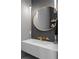 Modern bathroom features a sleek vanity, gold fixtures, elegant lighting, and a stylish round mirror at 4300 Bayshore Ne Blvd, St Petersburg, FL 33703