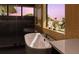 Modern freestanding bathtub with textured wall, candles, and picturesque window at 4300 Bayshore Ne Blvd, St Petersburg, FL 33703