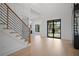 Open-concept foyer with light wood floors, staircase, and a modern black front door at 4300 Bayshore Ne Blvd, St Petersburg, FL 33703