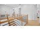 Bright upstairs hallway featuring wood floors, a modern railing, and white walls at 4300 Bayshore Ne Blvd, St Petersburg, FL 33703