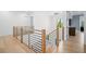 Upstairs landing features modern railing, hardwood floors, and accent wall, creating an inviting transition at 4300 Bayshore Ne Blvd, St Petersburg, FL 33703
