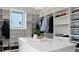 Bright walk-in closet boasts custom shelves, hanging racks, marble-top island, and a window with neighborhood views at 4300 Bayshore Ne Blvd, St Petersburg, FL 33703