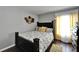 Cozy bedroom with hardwood floors, decorative wall art, and a comfortable queen-size bed illuminated by a nearby window at 4709 Puritan Cir # 702, Tampa, FL 33617