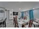 A dining room with a dining table, a decorative tv wall feature, gray walls and gray wood floors at 4709 Puritan Cir # 702, Tampa, FL 33617