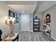 A foyer with gray wood floors, a decorative table lamp and an antique bookshelf with Gathering photos on the wall at 4709 Puritan Cir # 702, Tampa, FL 33617