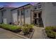 View of a two-story condo building featuring a landscaped yard with a cement walkway and black exterior stairs at 4709 Puritan Cir # 702, Tampa, FL 33617