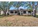 Exterior view of the back of a multi-unit home with screened in porches and mature landscaping at 4709 Puritan Cir # 702, Tampa, FL 33617