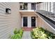 Exterior view of a building with stairs leading to the upper units, and landscaped front entrance at 4709 Puritan Cir # 702, Tampa, FL 33617