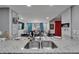 Bright kitchen featuring granite counters and stainless steel sink overlooking dining area with seating for six at 4709 Puritan Cir # 702, Tampa, FL 33617