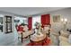 A living room with a white sofa set, gray walls, gray wood floors, red curtains, and a marble table at 4709 Puritan Cir # 702, Tampa, FL 33617
