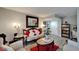A living room decorated with a white sofa and chair set, a red rug, gray walls, and gray wood floors at 4709 Puritan Cir # 702, Tampa, FL 33617