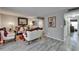 A living room with a white sofa and chair set, gray walls, gray wood floors, and ornate furnishings at 4709 Puritan Cir # 702, Tampa, FL 33617