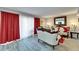 A living room with a white sofa and chair set, gray walls, gray wood floors, and red curtains at 4709 Puritan Cir # 702, Tampa, FL 33617