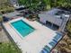 High angle view of community pool with lounge chairs and nearby covered area and mature landscaping at 4709 Puritan Cir # 702, Tampa, FL 33617
