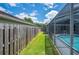 View of the backyard with a wooden fence and an enclosed pool area at 4761 Stoneview Cir, Oldsmar, FL 34677