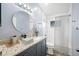 Updated bathroom featuring a granite countertop, a round mirror, and shower-tub combo at 4761 Stoneview Cir, Oldsmar, FL 34677