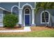 Close-up of the entrance with blue front door, columns, and manicured landscaping at 4761 Stoneview Cir, Oldsmar, FL 34677