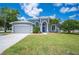 Charming single-story home with a well-manicured lawn, blue door, and attached two-car garage at 4761 Stoneview Cir, Oldsmar, FL 34677