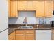 Well-lit kitchen with wood cabinets, granite countertops, stainless steel sink and white appliances at 4858 Coquina Key Se Dr # C, St Petersburg, FL 33705