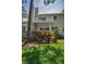 Scenic backyard featuring green grass, shrubs, and a condo balcony above at 5115 S Jules Verne Ct, Tampa, FL 33611